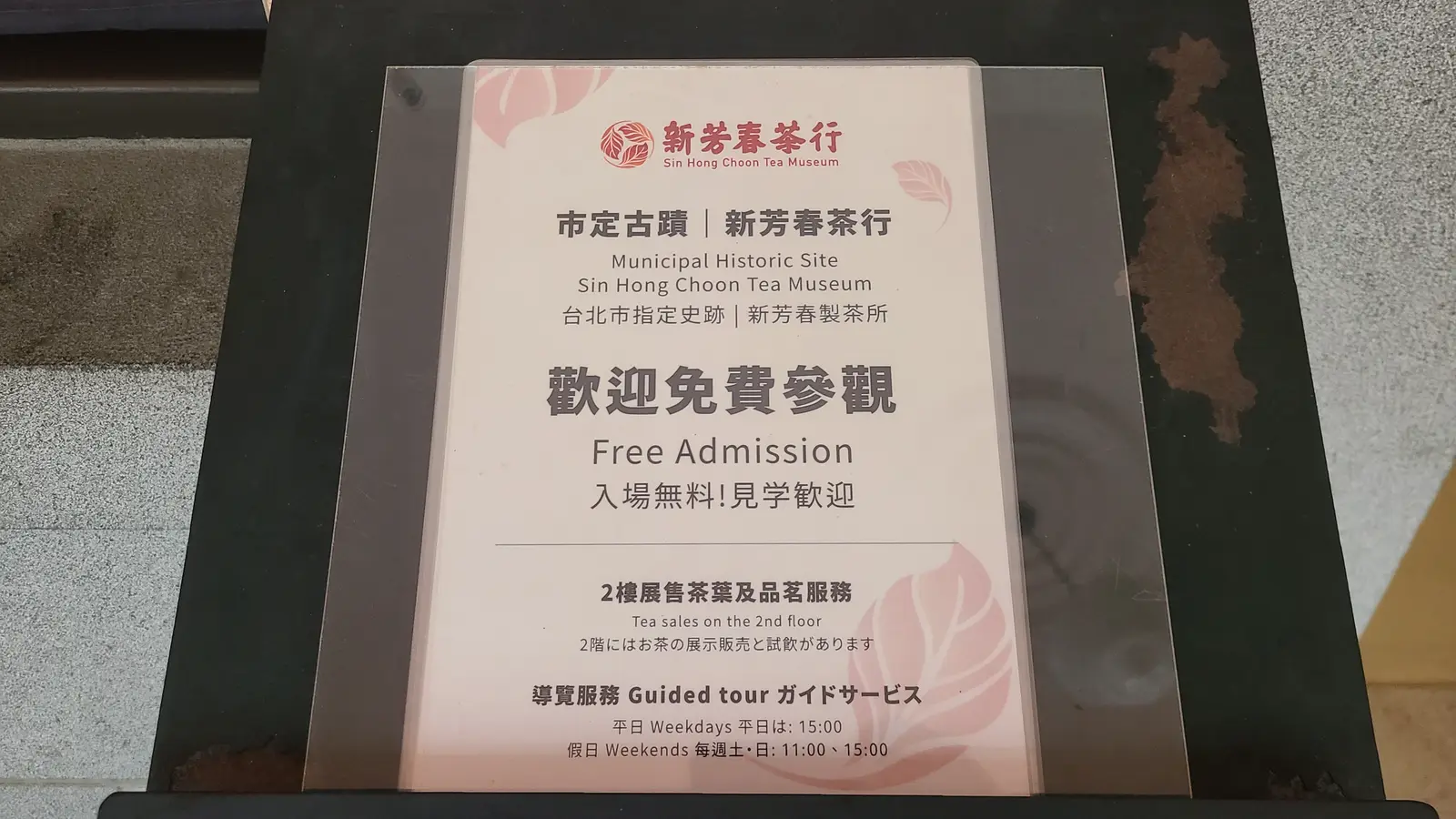 新芳春茶行的入館告示牌:市定古蹟、歡迎免費參觀、2 樓展售茶葉與導覽服務時間